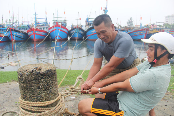 Residents in Tho Quang Ward, Da Nang City are seen tightening ropes to keep the anchored fishing boats secured during the coming typhoon. Photo: Truong Trung / Tuoi Tre