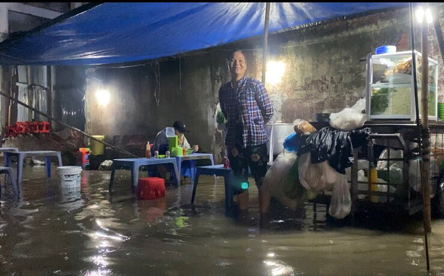 A woman displays her food stall on a flooded alley down Huynh Tan Phat Street in District 7, Ho Chi Minh City, September 27, 2022. Photo: Tuoi Tre