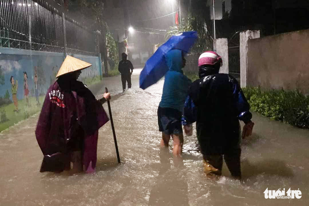 People walk along a flooded street in Nghe An Province, Vietnam, September 28, 2022. Photo: N.Thang / Tuoi Tre