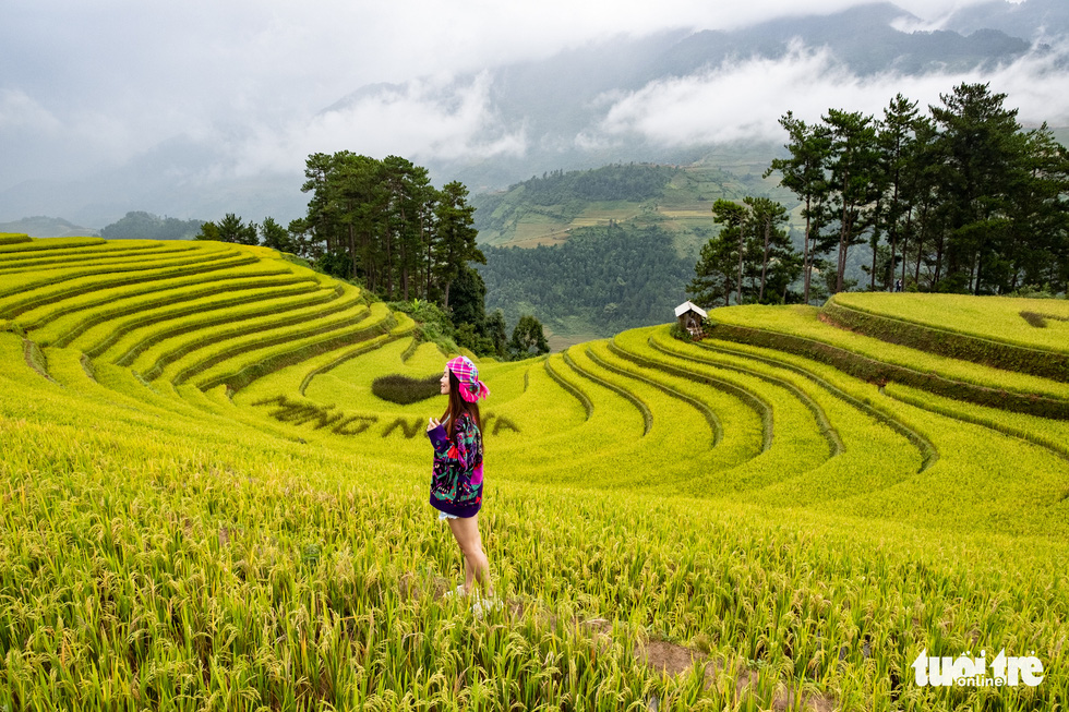 A woman poses for a photo on Mong Ngua Hill in Mo De Commune, Mu Cang Chai District, Vietnam. Photo: Nam Tran / Tuoi Tre