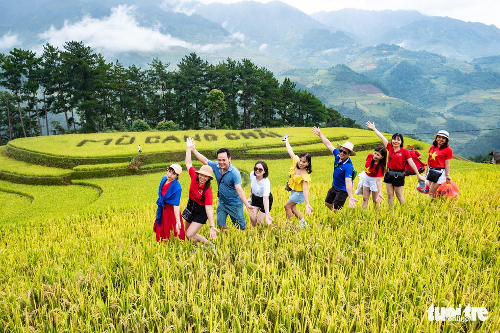 A group of tourists pose for a photo near a terraced field in Mu Cang Chai. Photo: Nam Tran / Tuoi Tre