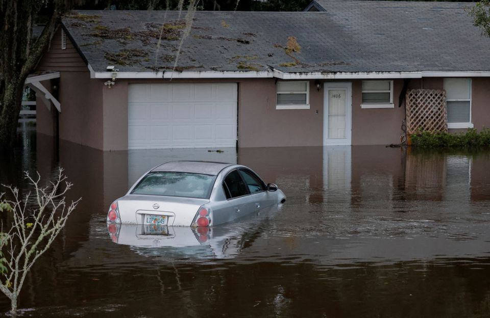 A partially submerged car and home are shown after Hurricane Ian caused widespread damage and flooding in Kissimmee, Florida, U.S., September 29, 2022. Photo: Reuters