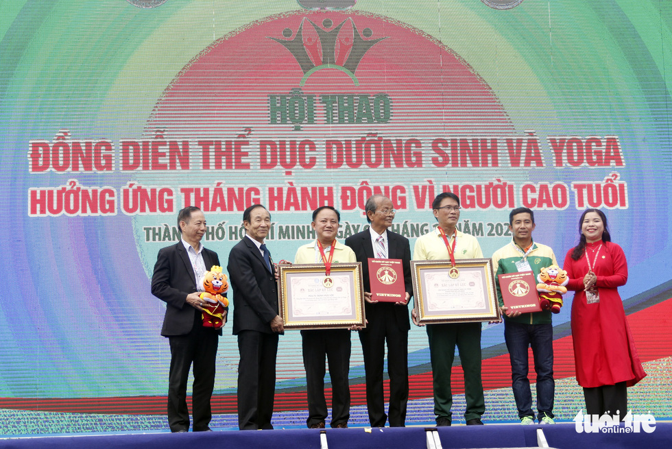 This image shows the record certificate presentation ceremony for the yangsheng gymnastics and yoga performance with the largest number of elderly participants in Vietnam.