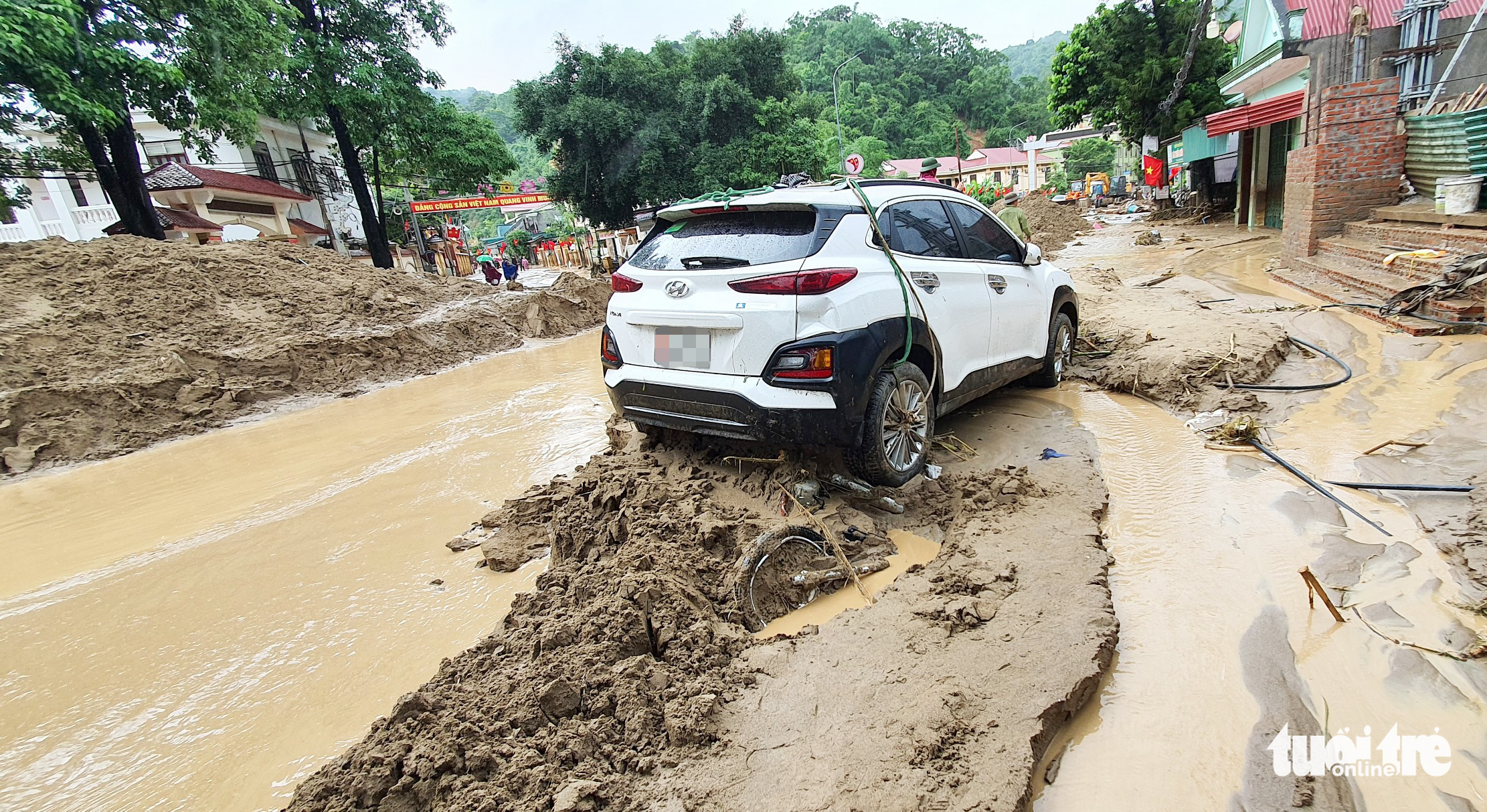 A car is left on a muddy street following a flash flood in Ky Son District, Nghe An Province, Vietnam, October 2, 2022. Photo: Duong Tinh / Tuoi Tre