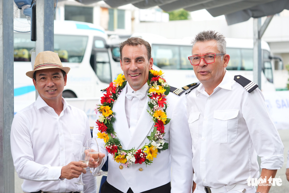 Captain Ludovic Provost (center) poses for a photo with representatives of local agencies in charge of welcoming the cruise ship. Photo: Huu Hanh / Tuoi Tre