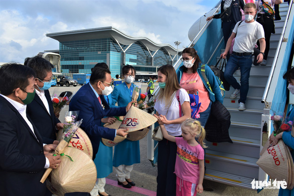 Tourism authorities present ‘non la’ (Vietnamese traditional hat) to foreign tourists at Cam Ranh International Airport, Khanh Hoa Province, central Vietnam. Photo: Minh Chien / Tuoi Tre