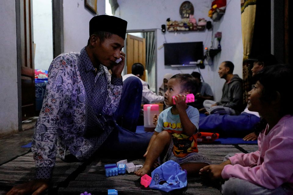 Andi Hariyanto, 36, a husband who lost his wife and two adopted children in a recent riot and stampede following a soccer match between Arema FC and Persebaya Surabaya at Kanjuruhan stadium, plays with his 2-year-old son Gean Putra Hariyanto, at his house in Malang, East Java province, Indonesia, October 4, 2022. Photo: Reuters