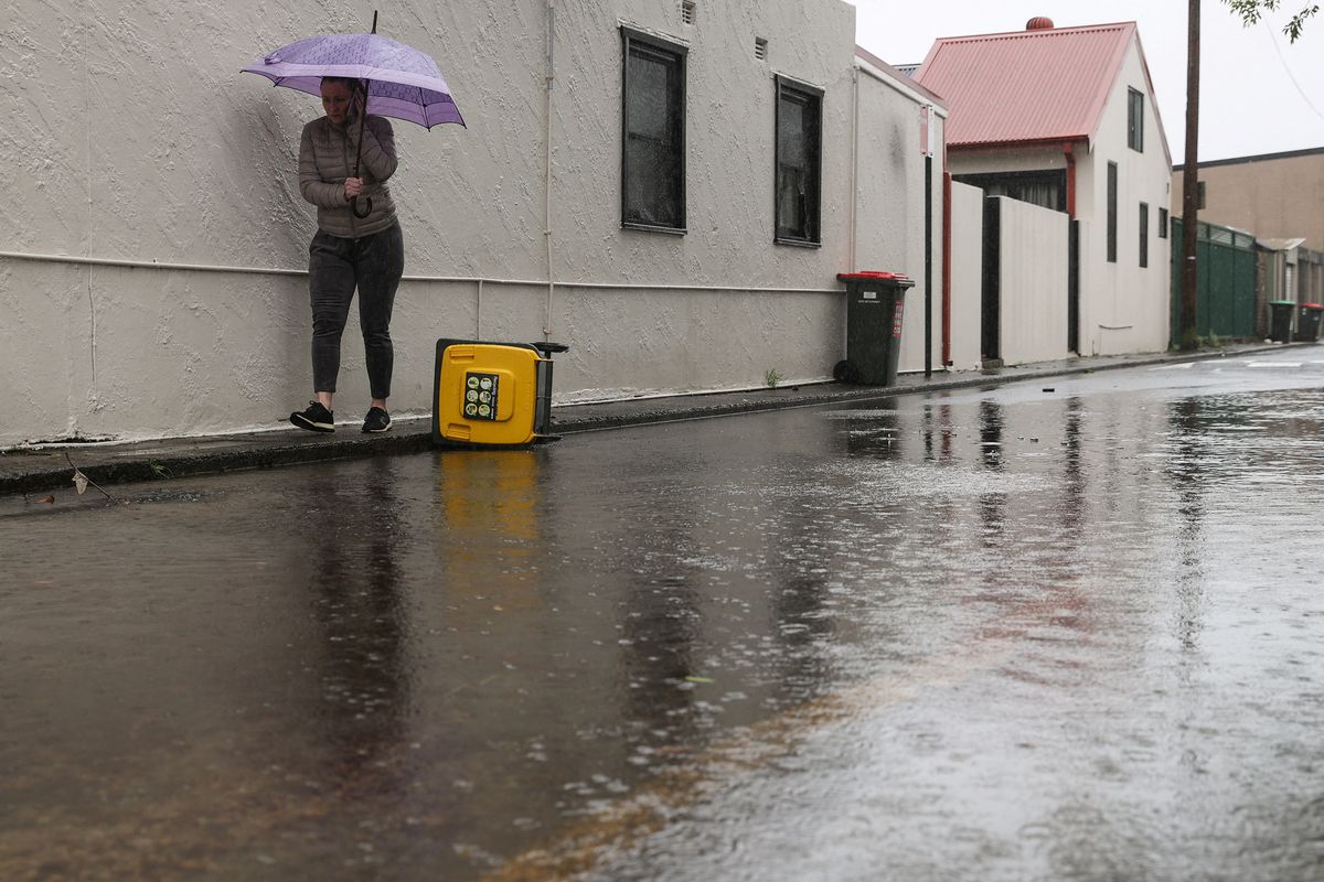 A pedestrian walks along a flooded street as heavy rains affect Sydney, Australia, October 6, 2022. Photo: Reuters