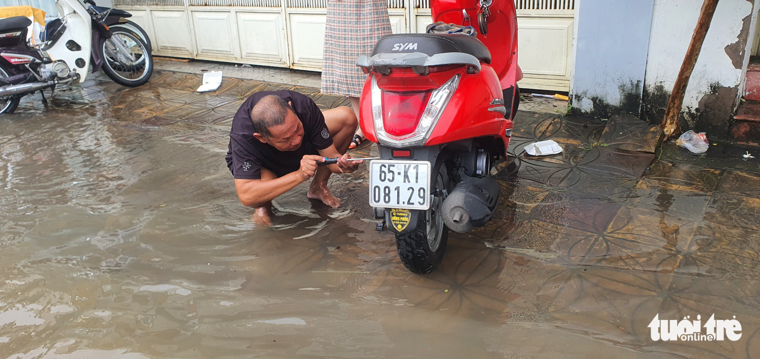 A man repairs a motorbike that broke down due to floodwater in Can Tho City, Vietnam, October 10, 2022. Photo: Chi Quoc / Tuoi Tre