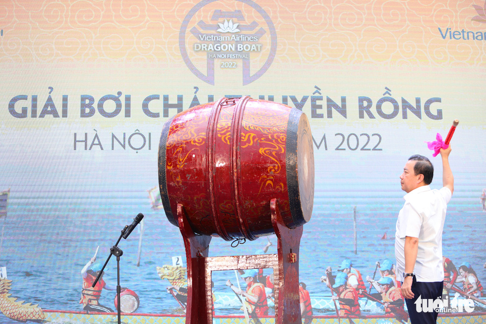 Chu Xuan Dung, deputy chairman of the Hanoi People’s Committee, beats the drum to inaugurate the 2022 Hanoi Open Boat Race Tournament. Photo: Danh Khang / Tuoi Tre