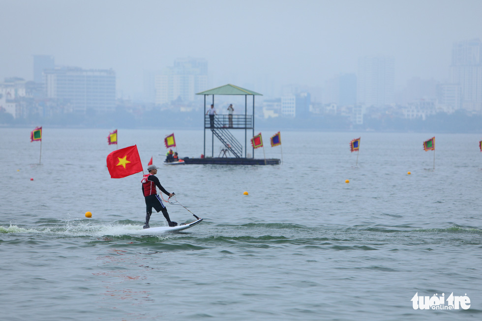 A man does a performance on a water board before the race on West Lake, Hanoi, October 9, 2022. Photo: Danh Khang / Tuoi Tre