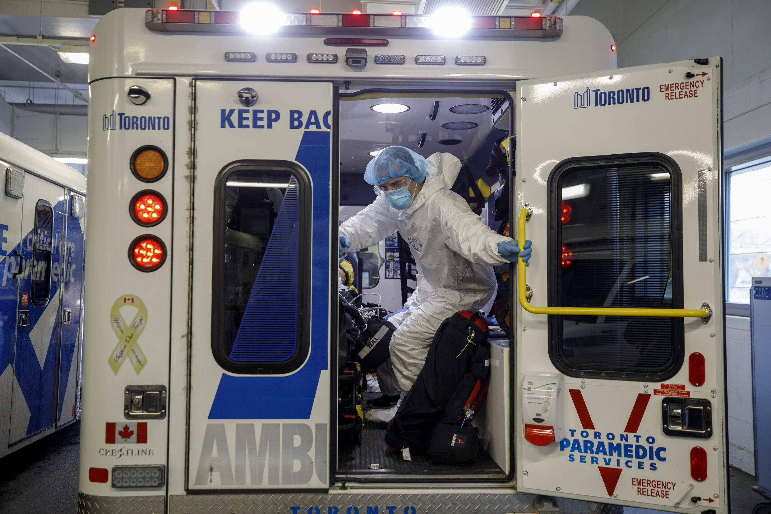 Paramedics, such as these seen at Toronto Humber River Hospital in April 2021, are often stuck waiting at overwhelmed ERs to unload patients. Cole Burston AFP/File