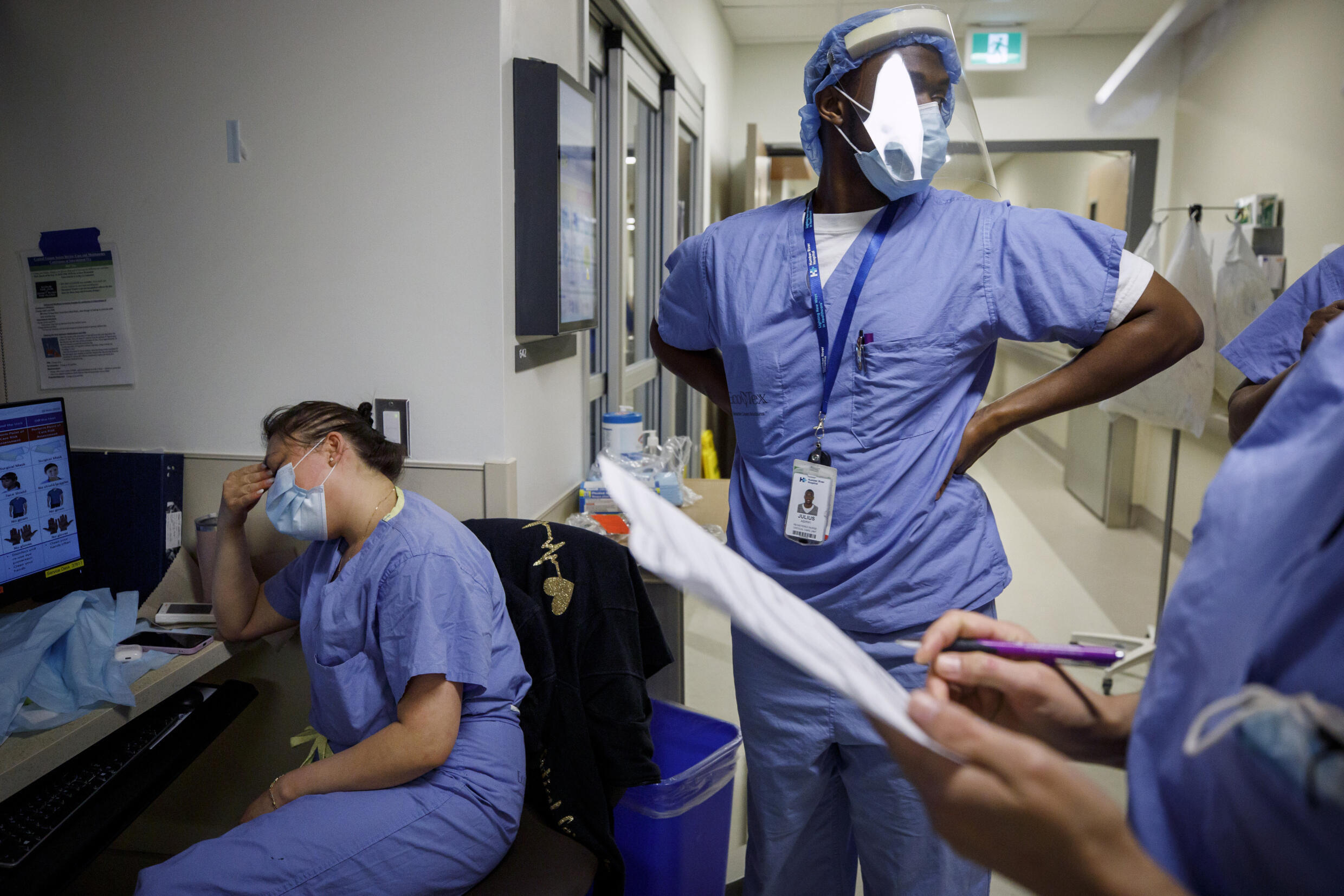 A tired nurse holds her head after a long shift at Toronto's Humber River Hospital in April 2021; workloads have become heavier since then, prompting a health care crisis. Cole Burston AFP/File