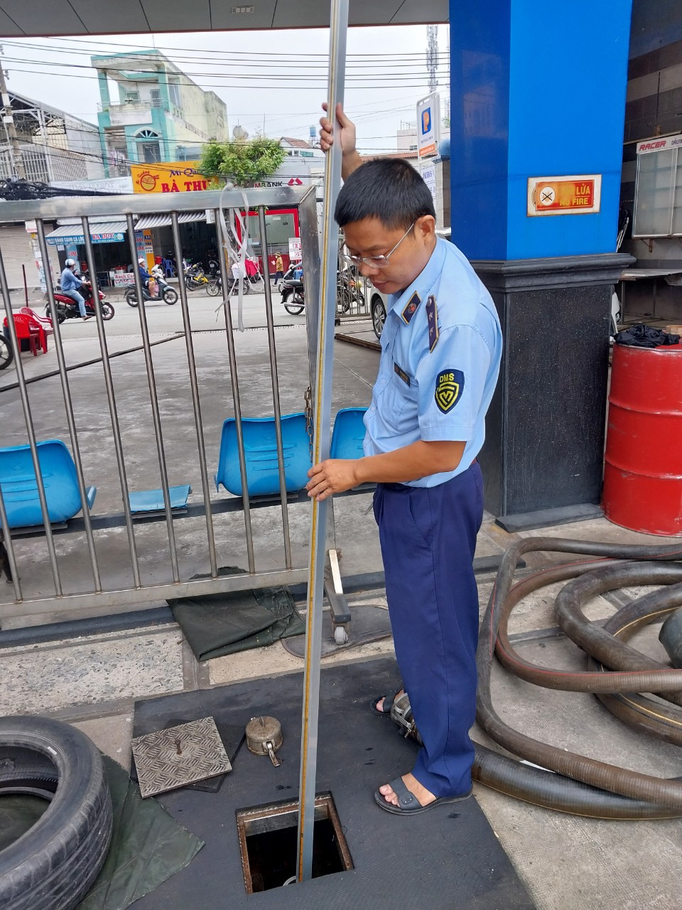 An official of the Ho Chi Minh City Market Surveillance Agency measures a gasoline tank at a filling station to check if the station is hoarding fuel. Photo: The Ho Chi Minh City Market Surveillance Agency