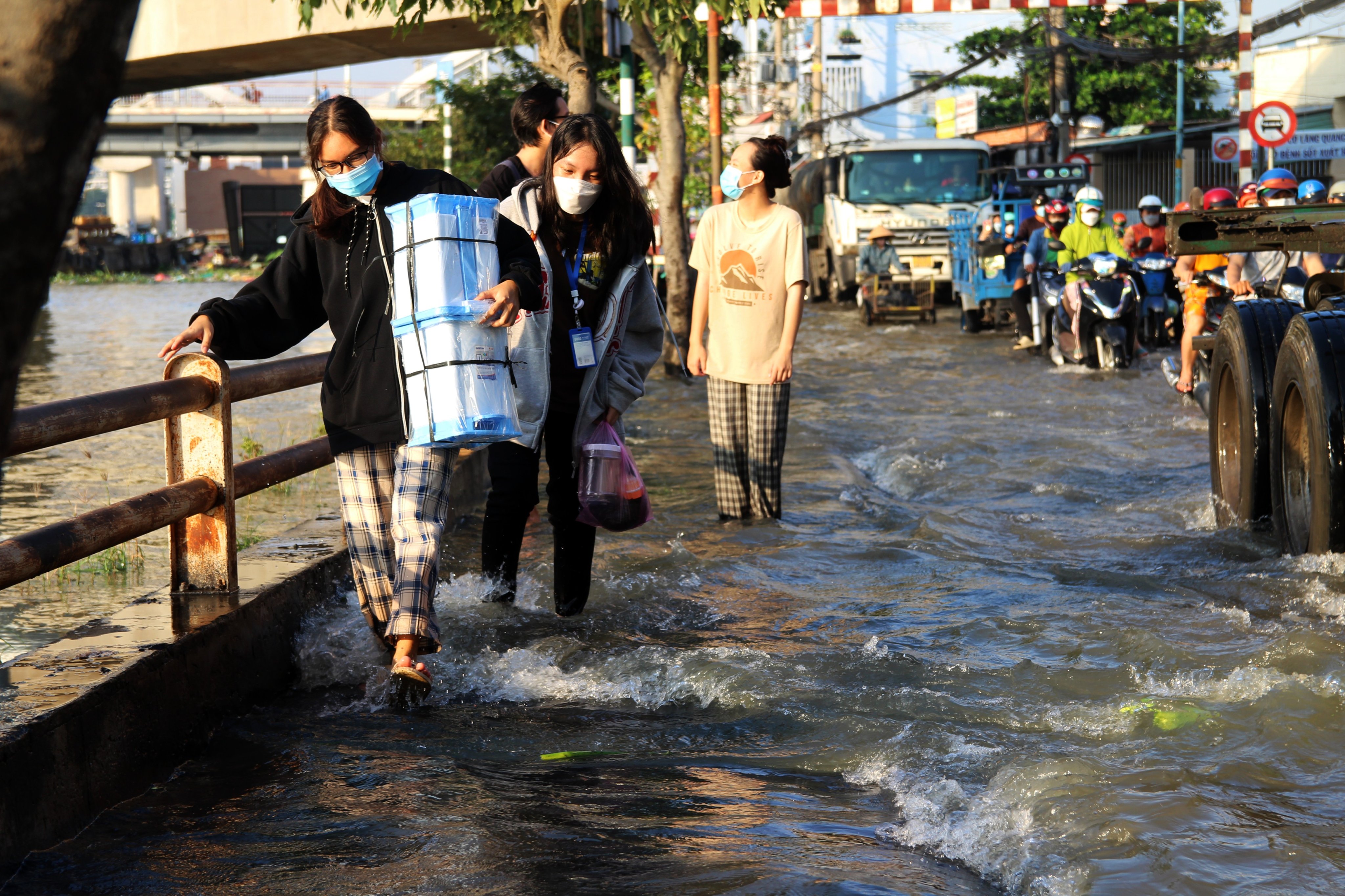 People walk on flooded Tran Xuan Soan Street in District 7, Ho Chi Minh City, October 10, 2022. Photo: Tuoi Tre