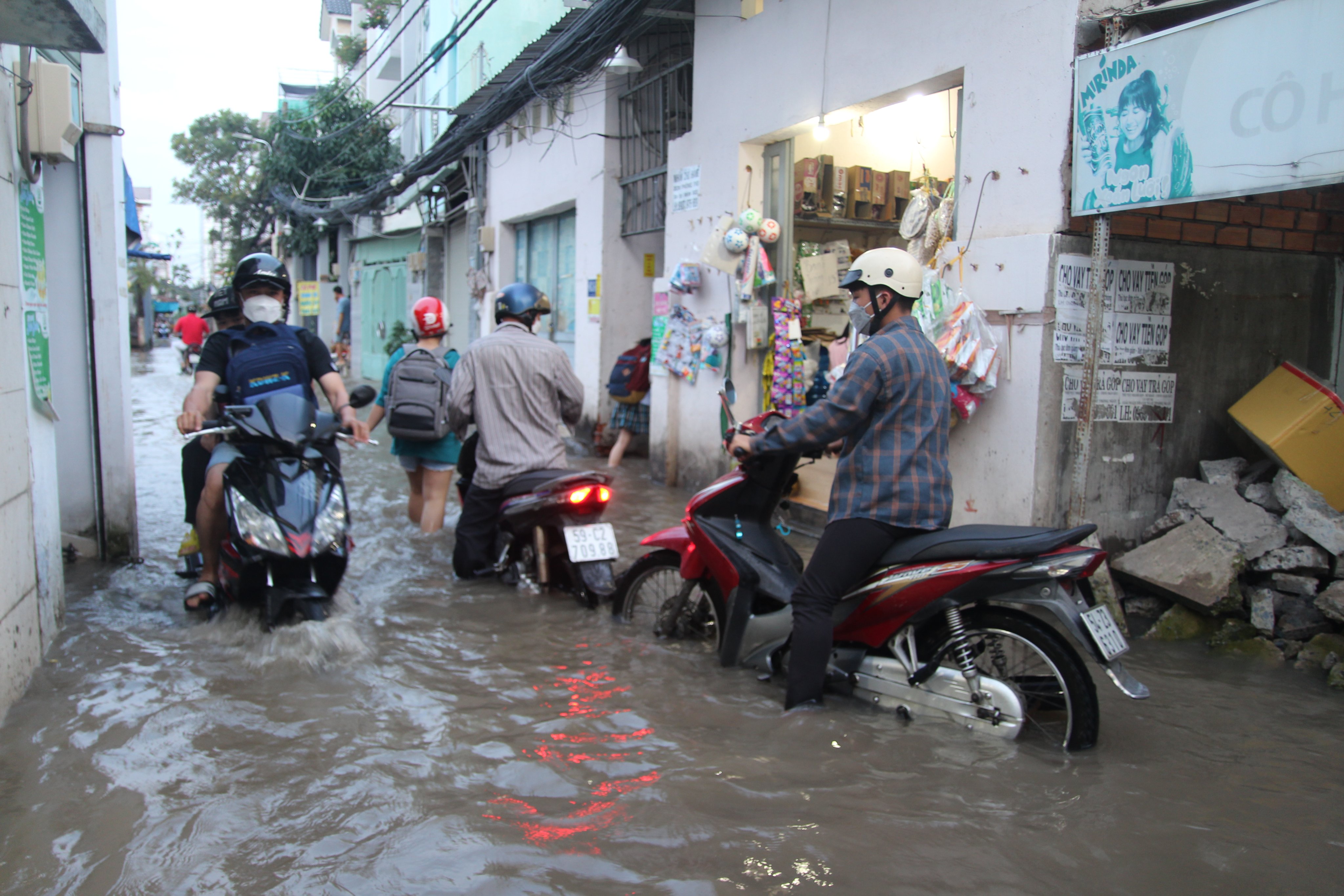 People travel on a flooded street in District 7, Ho Chi Minh City, October 10, 2022. Photo: Tuoi Tre