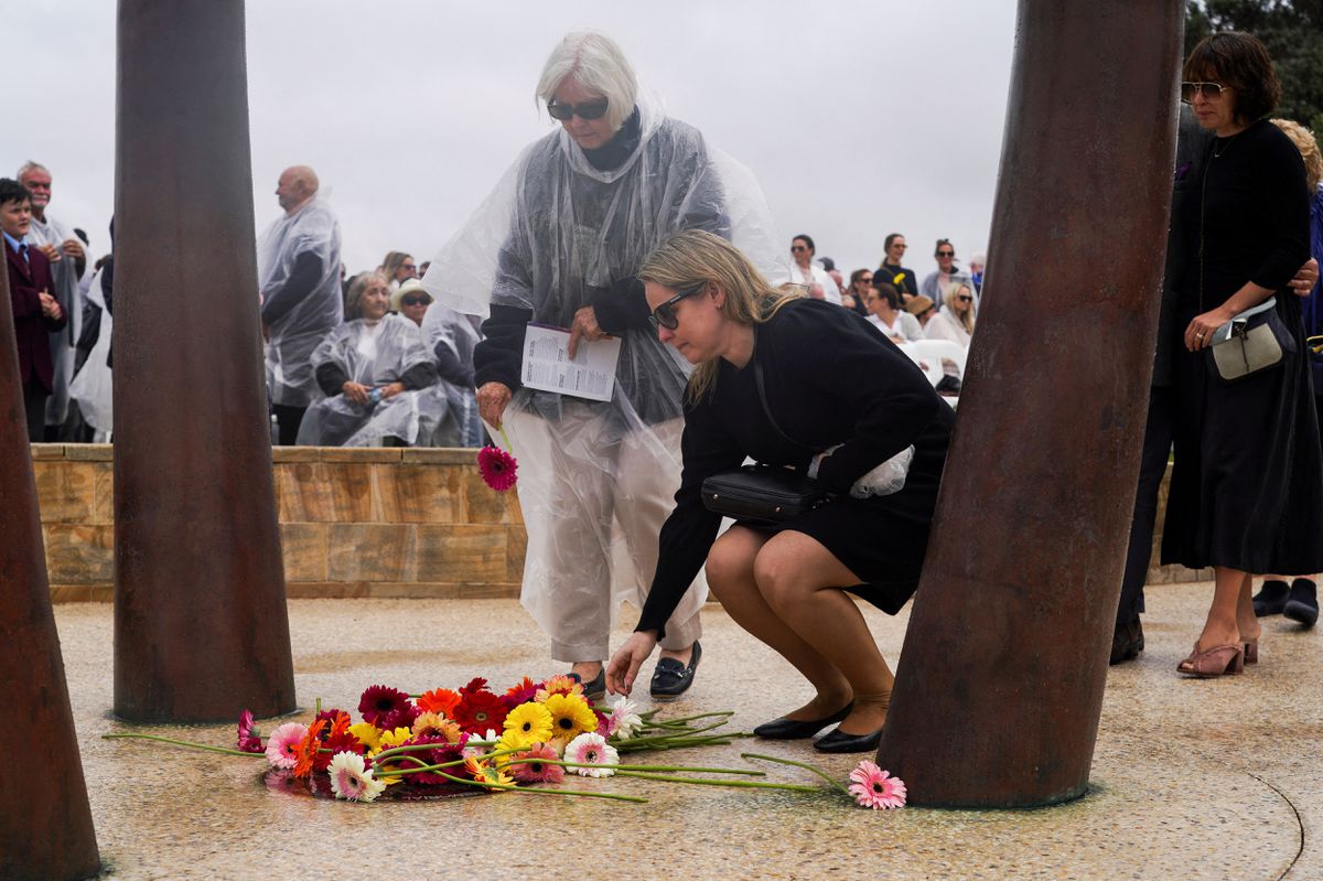 Mourners take part in a flower laying ceremony during a memorial service to mark the 20th anniversary of the Bali bombings, which killed 202 people including 88 Australians, at Coogee Beach in Sydney, Australia, October 12, 2022. REUTERS/Loren Elliott