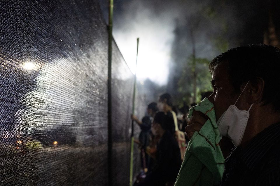 A person reacts as people gather near the funeral pyres of victims, during a cremation ceremony at Wat Rat Samakee temple, following a mass shooting at a day care centre in the town of Uthai Sawan, in the province of Nong Bua Lam Phu, Thailand, October 11, 2022. Photo: Reuters