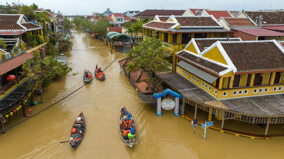 This image shows small boats carrying passengers in an inundated area that is a pedestrian street serving as a night market area in Hoi An Ancient Town. Photo: Mai Thanh Chuong