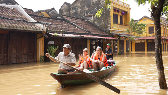 This image shows foreigners taking a ‘boat tour’ of heavily flooded Hoi An Ancient Town in Hoi An City, Quang Nam Province, central Vietnam on October 11, 2022. Photo: Mai Thanh Chuong