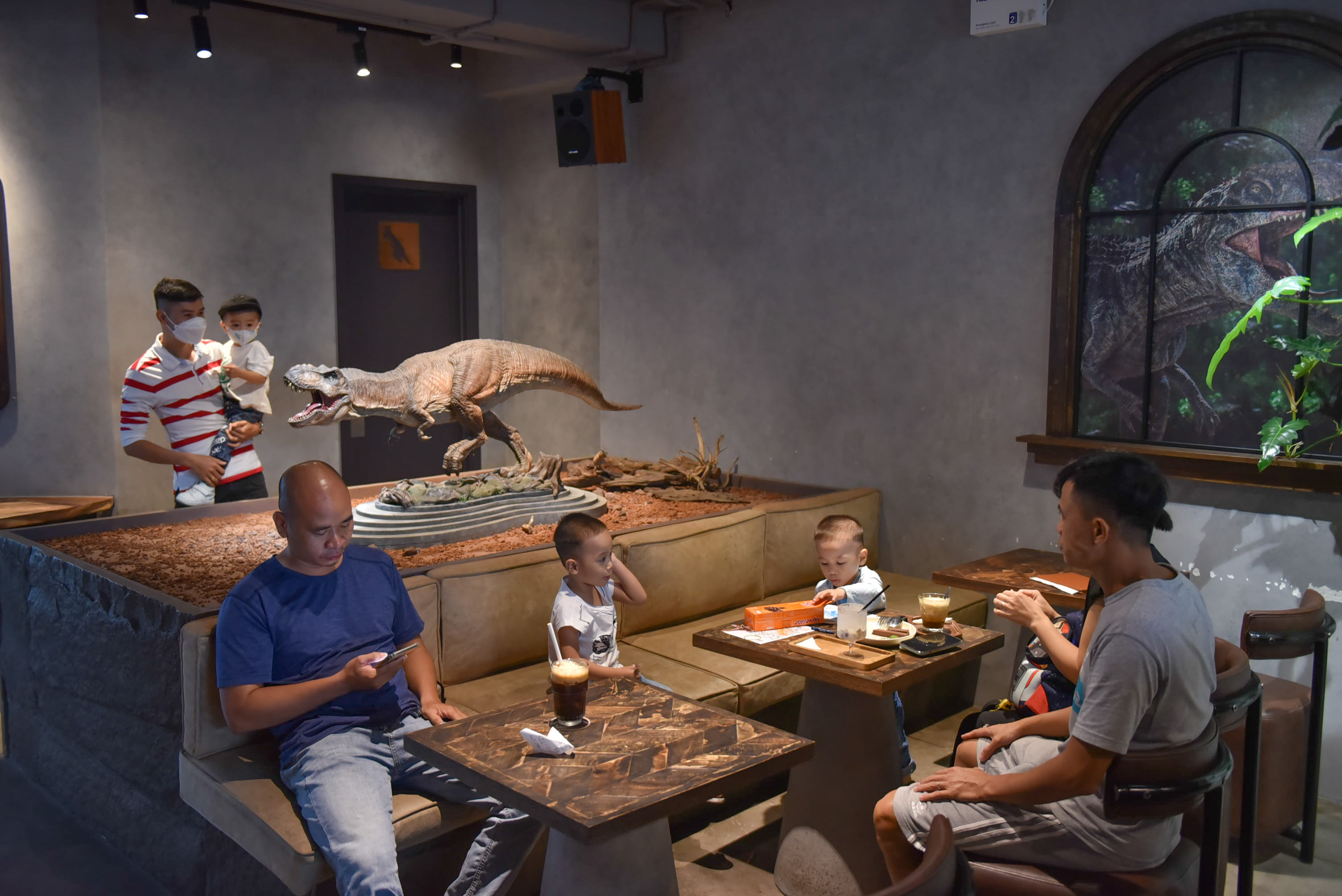 Families and children enjoy dinosaur models while have drinks at SAURUS Coffee & Gallery in Go Vap District, Ho Chi Minh City. Photo: Ngoc Phuong / Tuoi Tre News