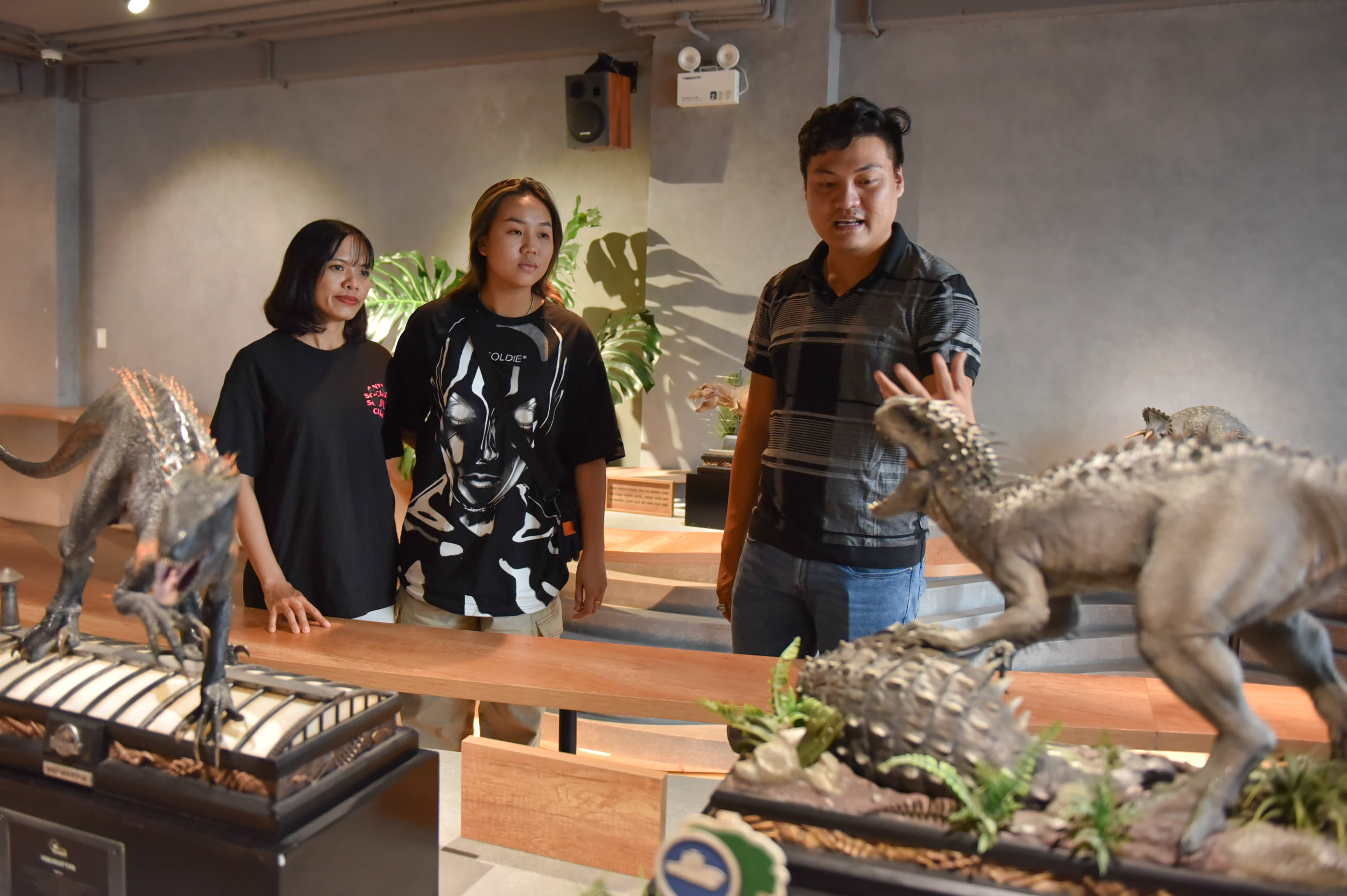 Owner Pham Cong Ly (right) discusses dinosaurs with a guest at SAURUS Coffee & Gallery in Go Vap District, Ho Chi Minh City. Photo: Ngoc Phuong / Tuoi Tre News