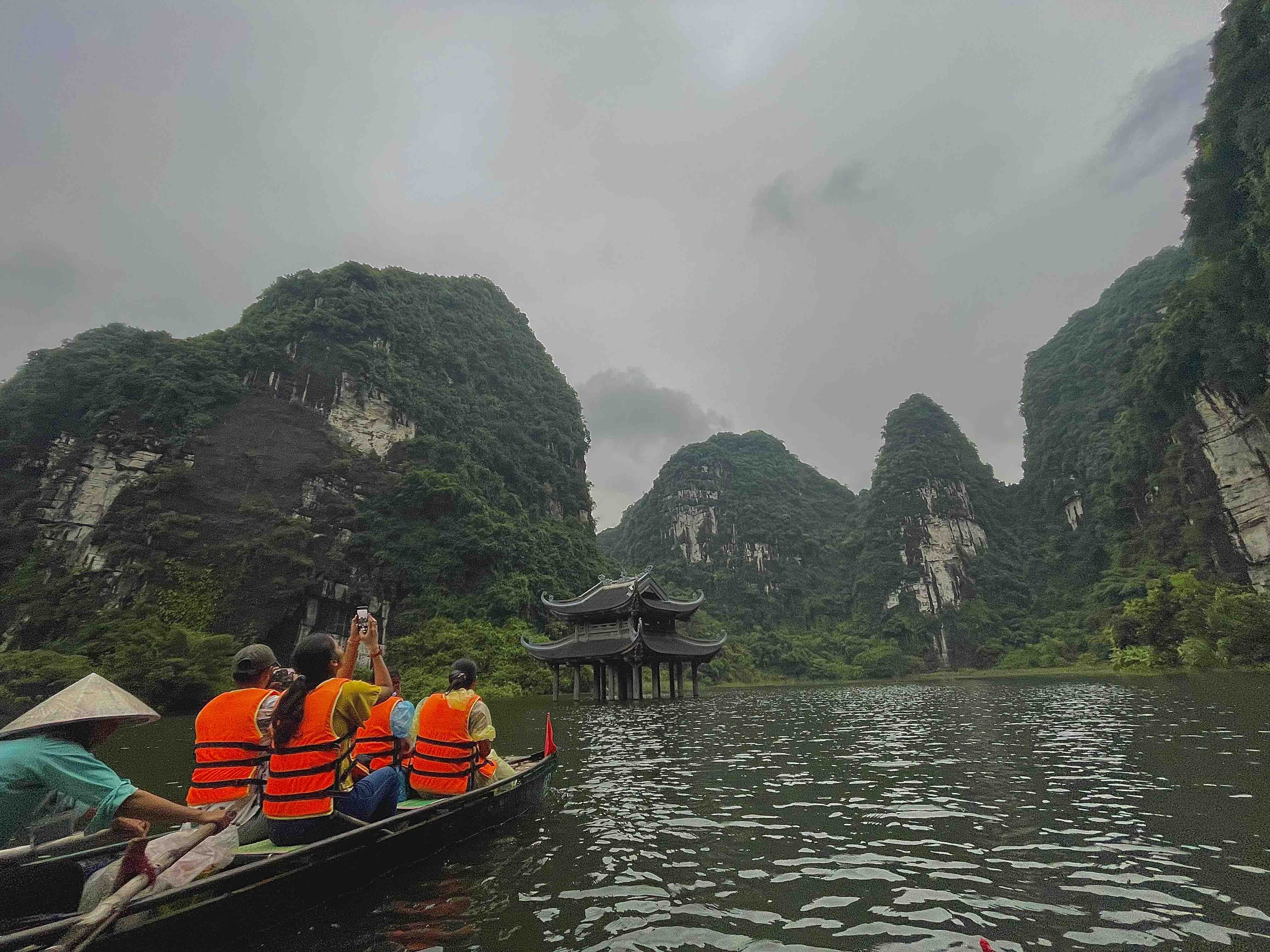 A tourist takes photos of the scenery at Trang An Complex, Ninh Binh Province, Vietnam. Photo: Linh To / Tuoi Tre News