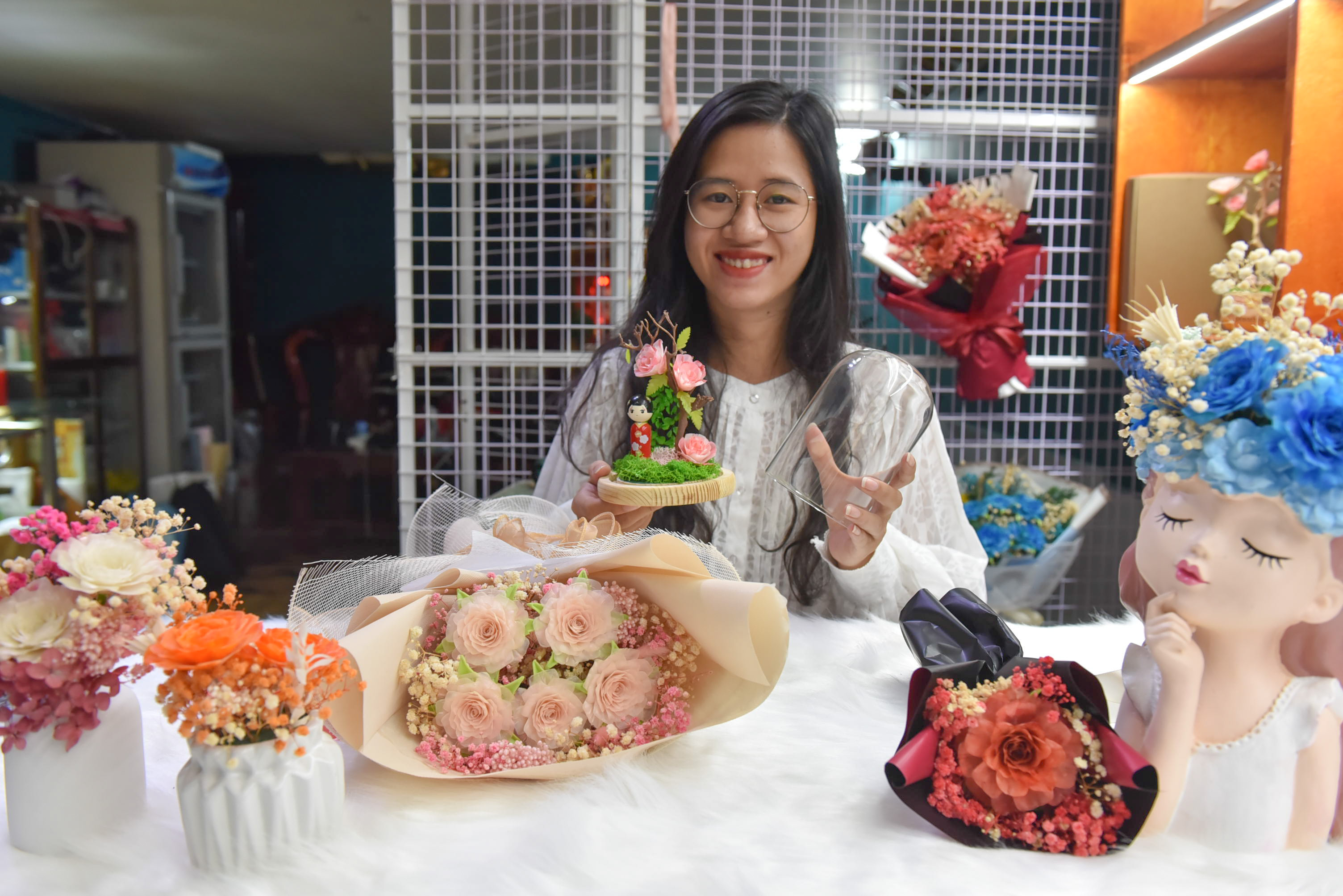 Pham Nhu Quynh and the flowers made from fish scales at her shop. Photo: Ngoc Phuong / Tuoi Tre News.
