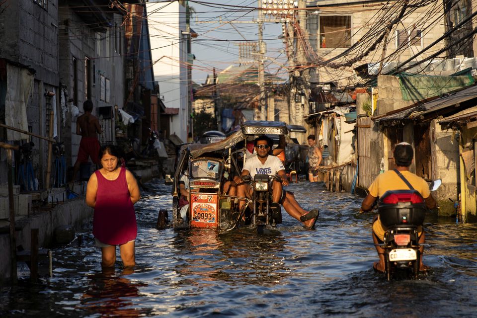 A motorcycle taxi, modified to cope with flooding, rides at the coastal town of Hagonoy, Bulacan province, Philippines, September 23, 2022. Photo: Reuters