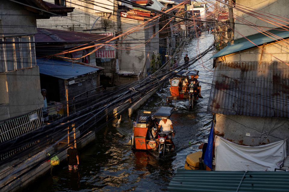 Motorcycle taxis, modified to cope with flooding, ride at the coastal town of Hagonoy, Bulacan province, Philippines, September 23, 2022. Photo: Reuters