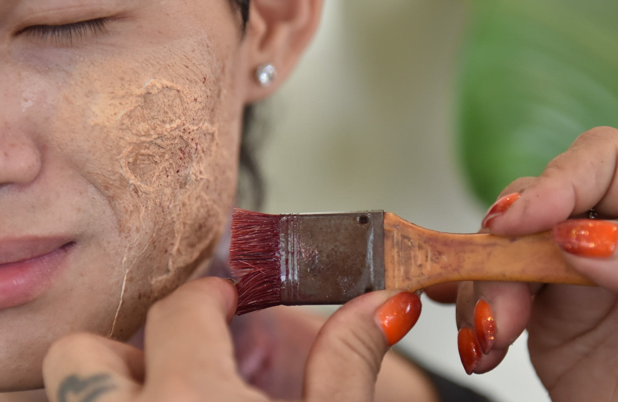 Hang uses a brush to splash fake blood on an actor’s wound. Photo: Ngoc Phuong / Tuoi Tre News