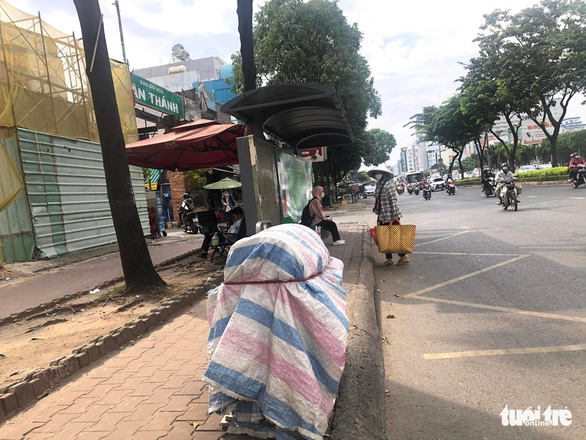 A trash can is completely covered with canvas next to a bus stop on Dien Bien Phu Street in Binh Thanh District, Ho Chi Minh City. Photo: Tuoi Tre
