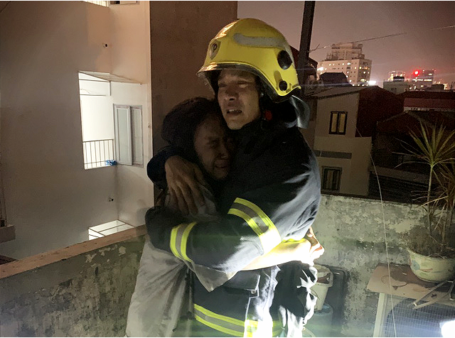 A woman hugs a firefighter after being saved from a fire at a house in Cau Giay District, Hanoi, October 23, 2022. Photo: Hung Dung / Tuoi Tre