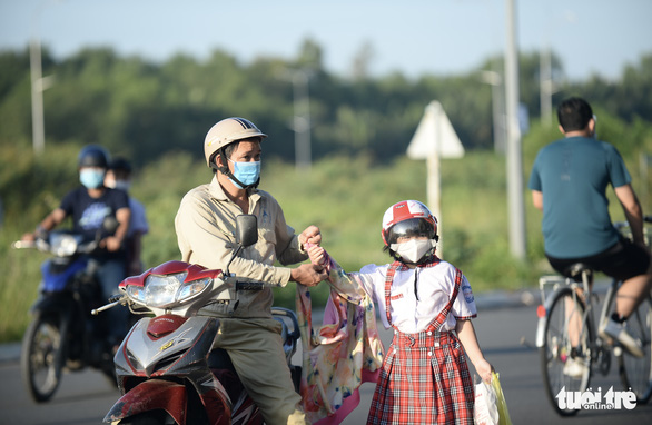 A man drops his daughter off at school in Nha Be District, Ho Chi Minh City. Photo: Tu Trung / Tuoi Tre