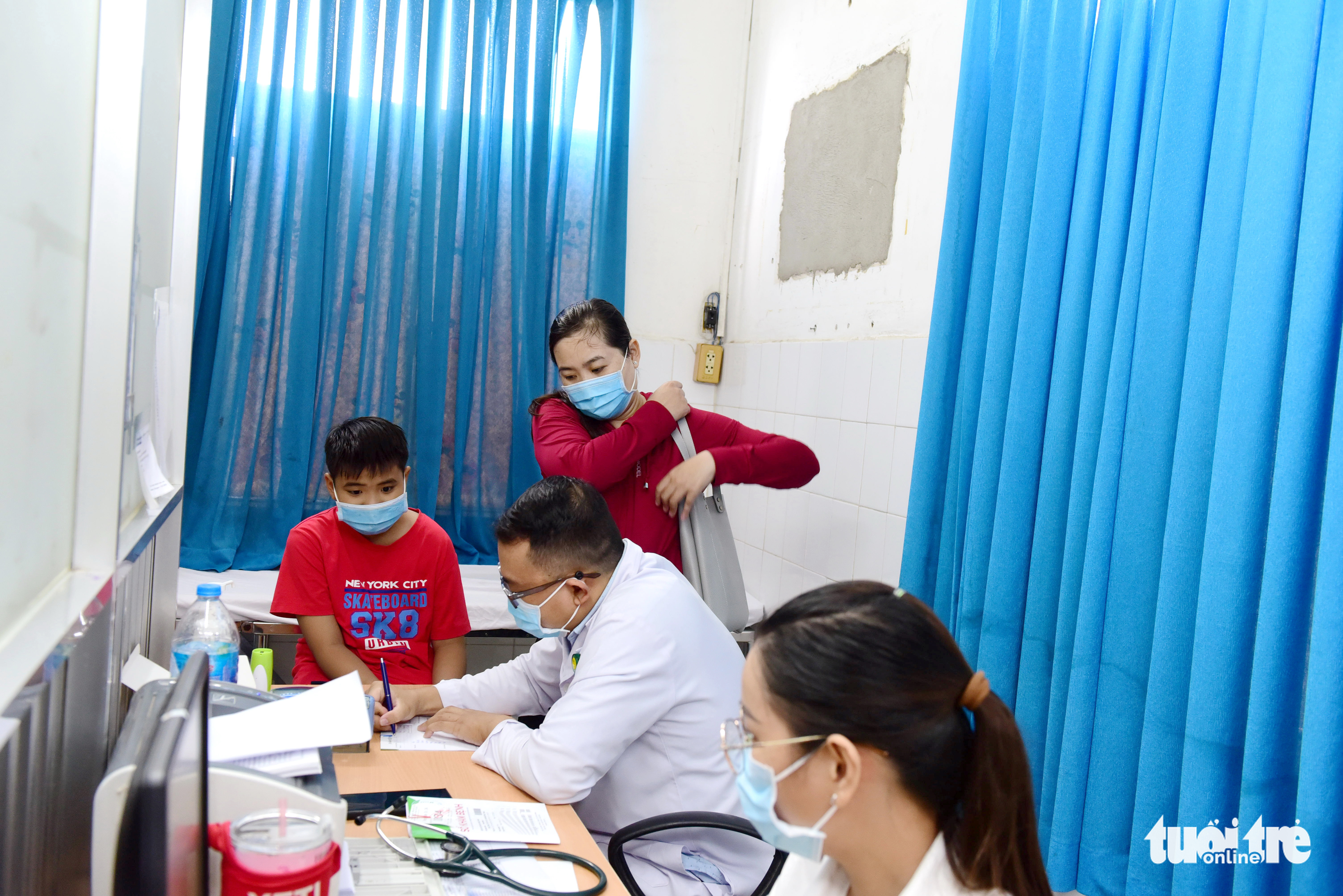 A doctor examines a child patient in a narrow room at the medical examination department of the Ho Chi Minh City Hospital for Tropical Diseases. Photo: Duyen Phan / Tuoi Tre