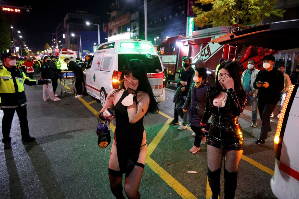 Partygoers walk by ambulances at the scene where dozens of people were injured in a stampede during a Halloween festival in Seoul, South Korea, October 30, 2022. Photo: Reuters