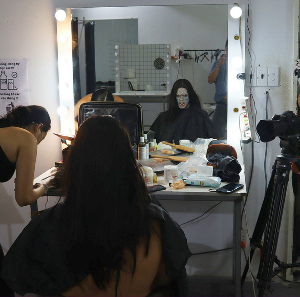 A makeup artist does Halloween makeup for a customer at her house. Photo: M.L. / Tuoi Tre