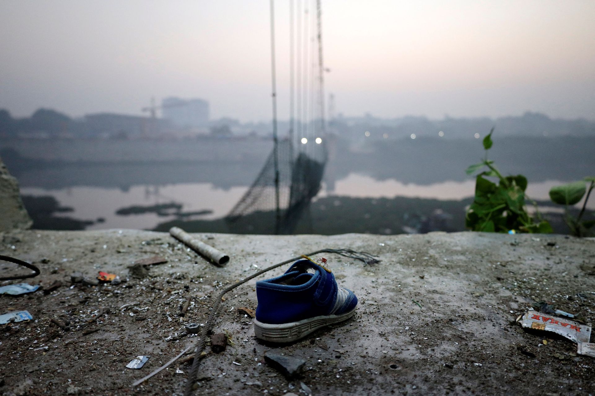 A shoe lies near a damaged suspension bridge after it collapsed on Sunday, in Morbi town in the western state of Gujarat, India, November 1, 2022. Photo: Reuters