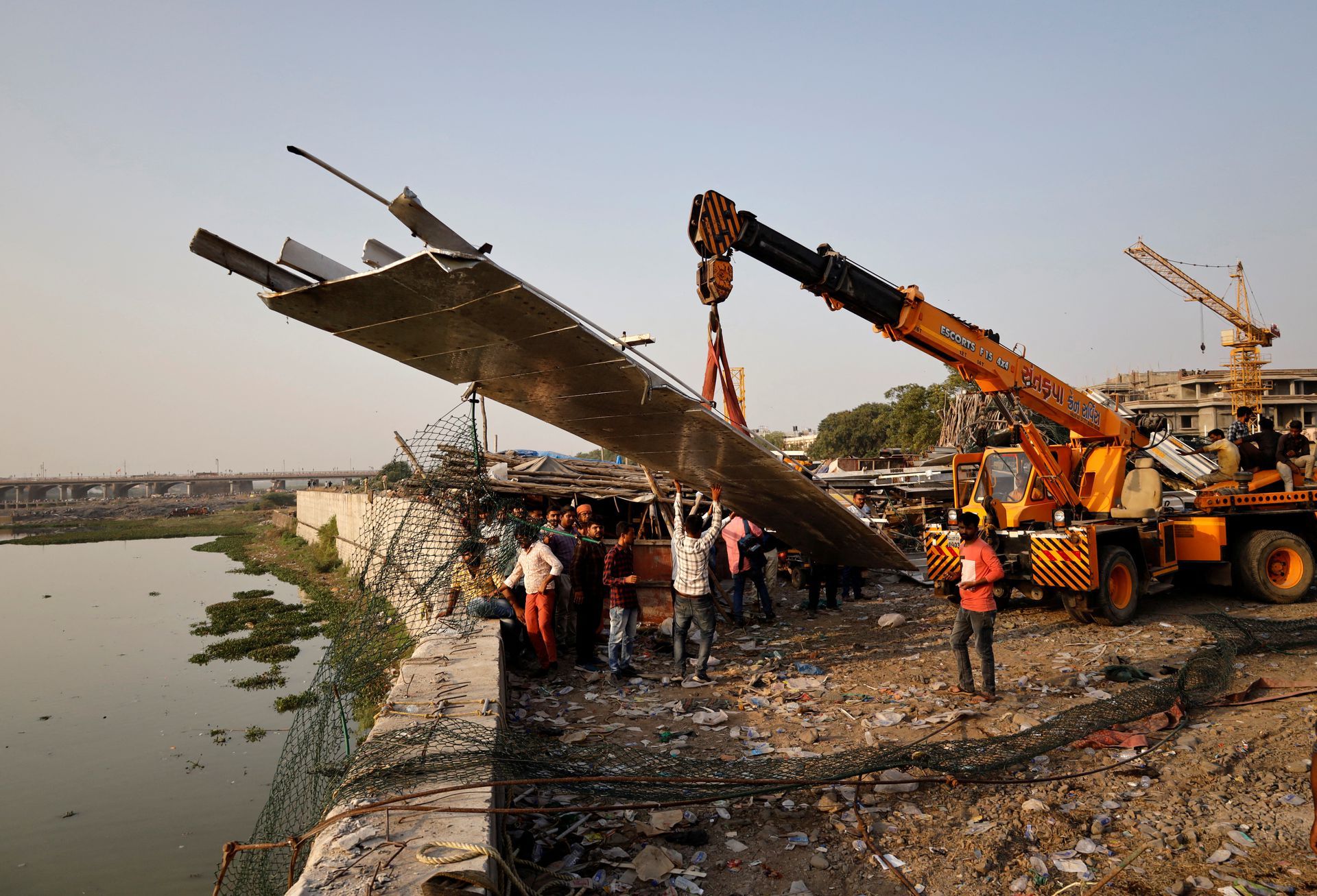 People remove debris after a suspension bridge collapsed in Morbi town in the western state of Gujarat, India, October 31, 2022. Photo: Reuters