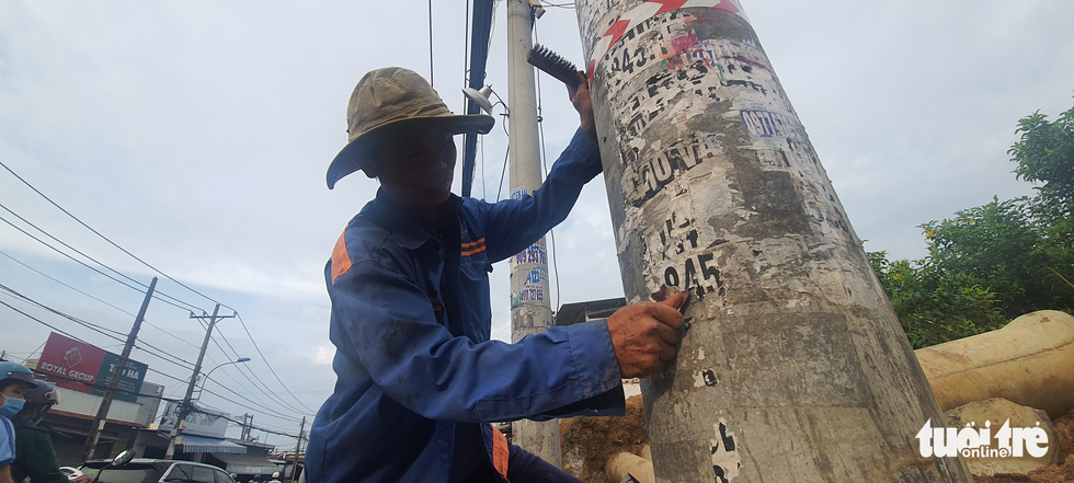 A resident finds it hard to clear ads from a power pole.