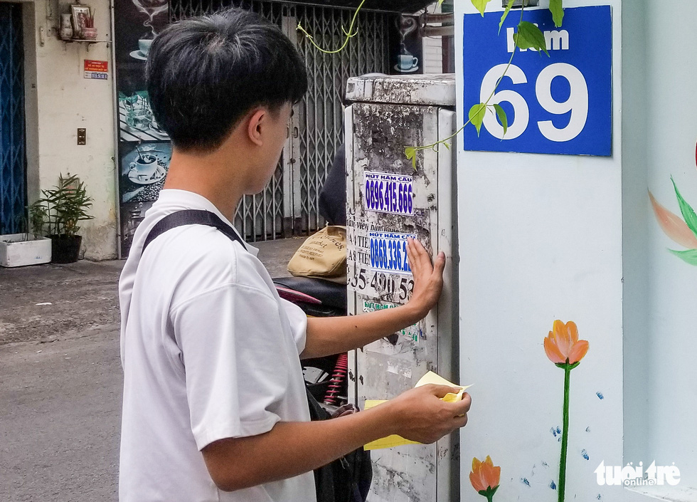 An employee of Bom sticks ads in Phu Nhuan District, Ho Chi Minh City.