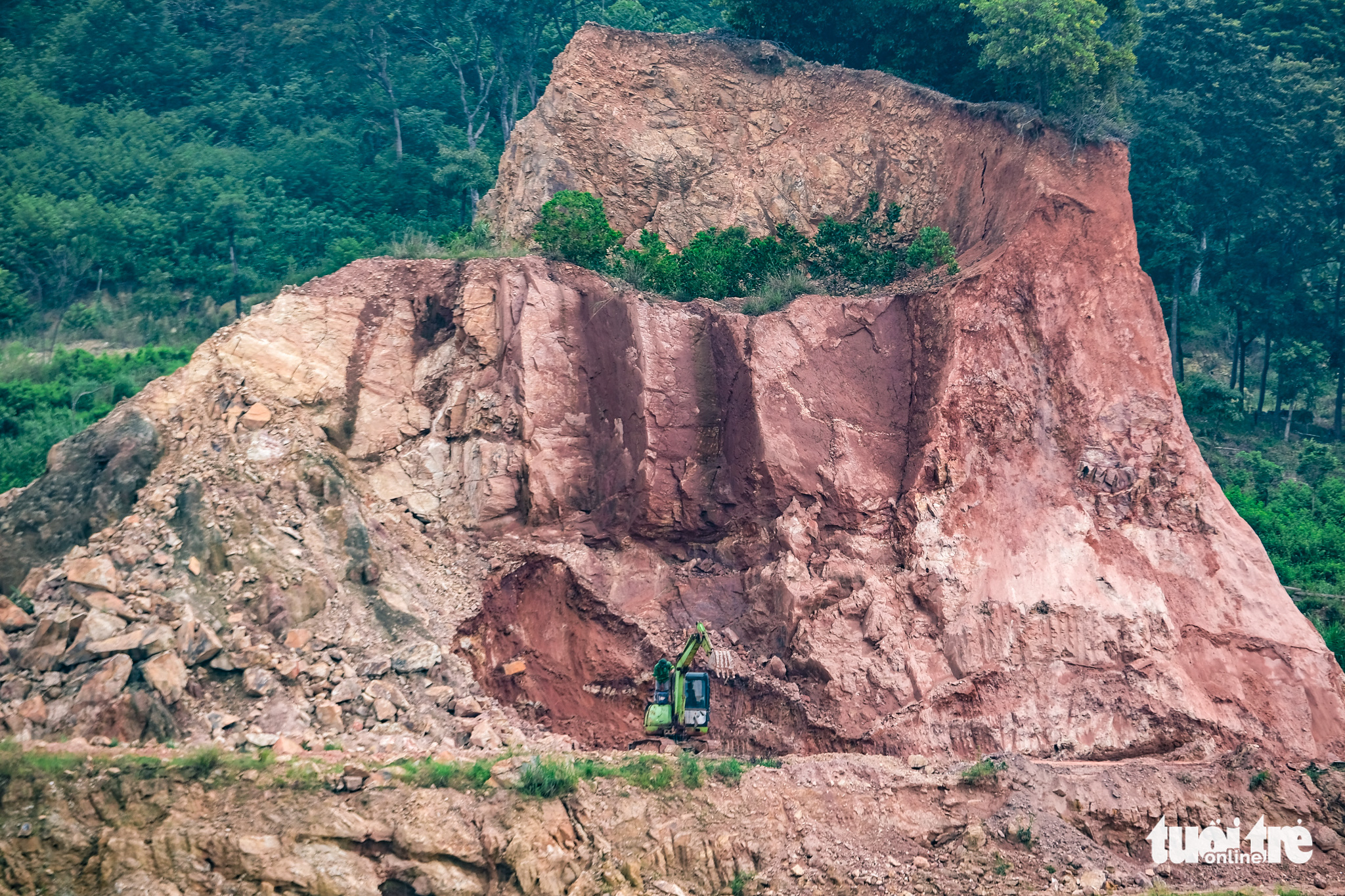 An excavator works on a flank of the destroyed Dinh mountain in Vinh Phuc Province, Vietnam. Photo: Tuoi Tre