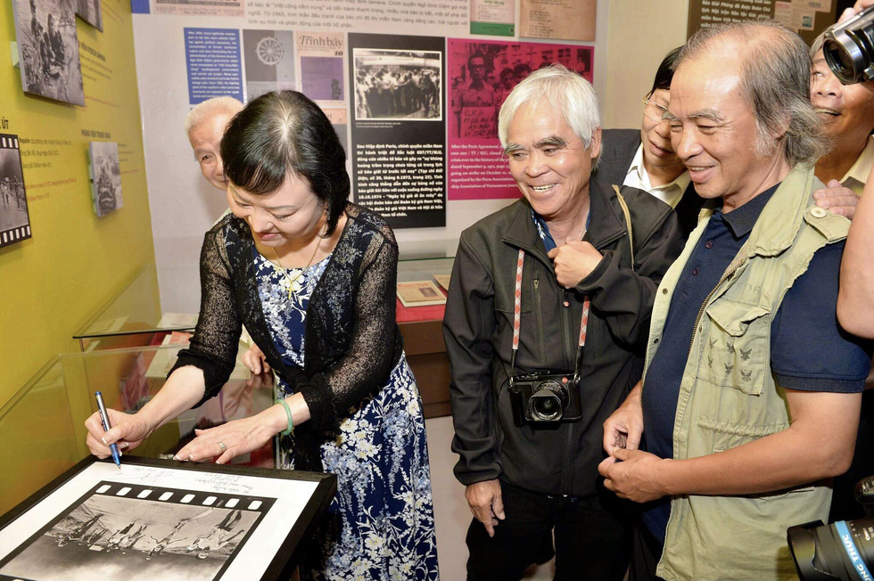 Nick Ut and Phan Thi Kim Phuc sign a photo of ‘Napalm Girl’ during a meeting at the Vietnam Press Museum in Hanoi, Vietnam. Photo: Supplied