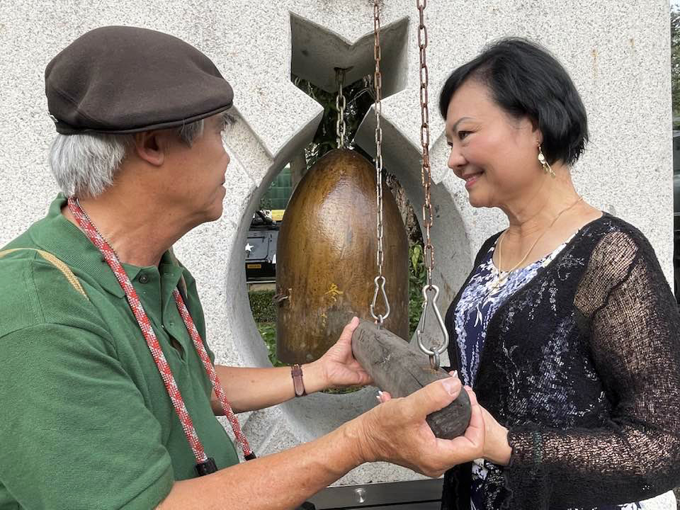 Nick Ut and Phan Thi Kim Phuc strike a bell at the War Remnants Museum in Ho Chi Minh City. Photo: Supplied