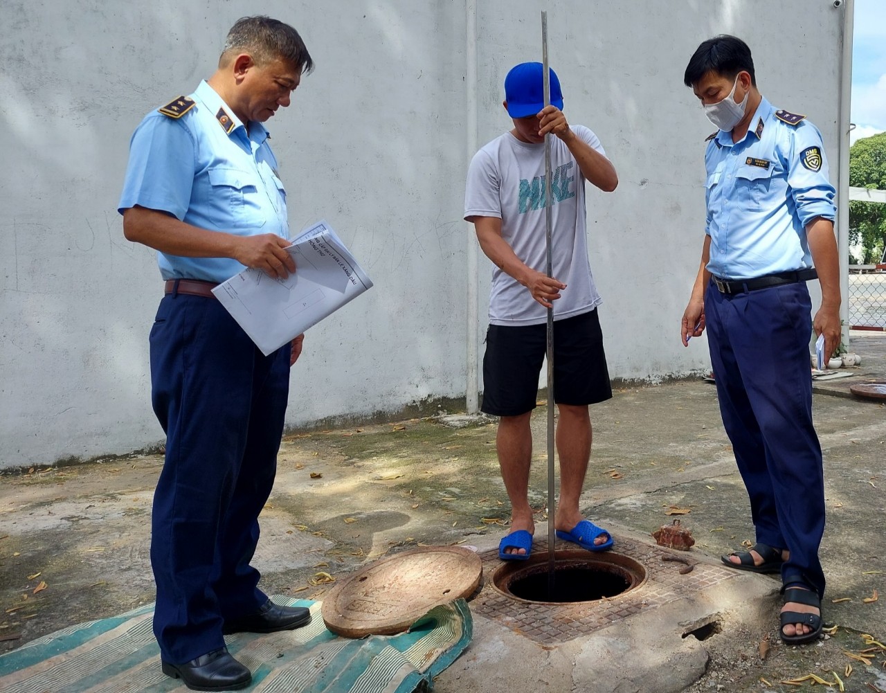 Market surveillance officers measure a gasoline tank at a filling station in Tan Phu District, Ho Chi Minh City, November 13, 2022. Photo: N. Tri / Tuoi Tre