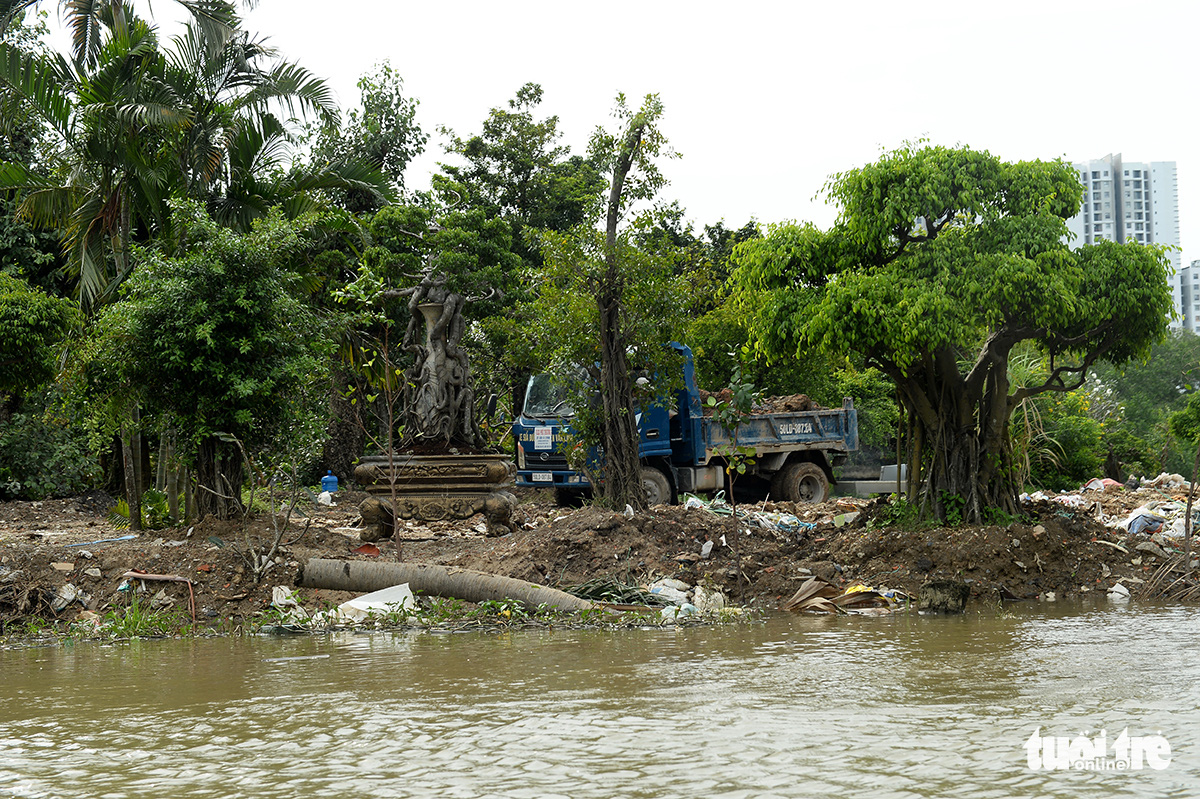 Construction vehicles work on a new plot that is formed by encroaching on a riverbed in Nha Be District, Ho Chi Minh City. Photo: Tu Trung / Tuoi Tre