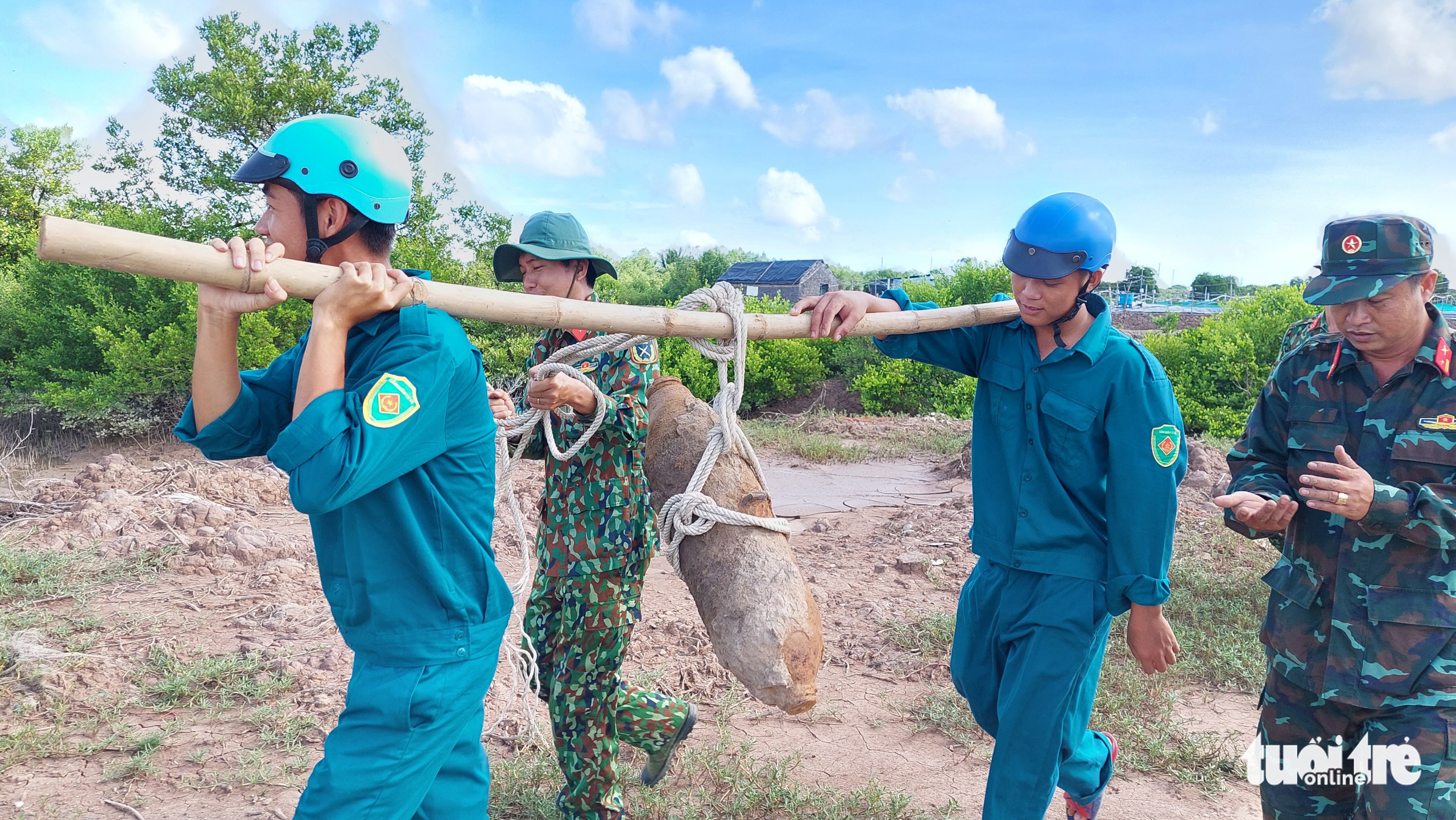 Military officers remove a 112-kilogram bomb from a shrimp pond in Tra Vinh Province, Vietnam. Photo: A.X. / Tuoi Tre