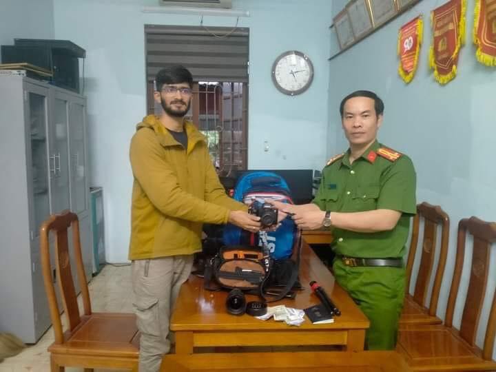 A police officer returns the stolen belongings to the Indian visitor at the police station in Thanh Hoa Province, Vietnam in this supplied photo.
