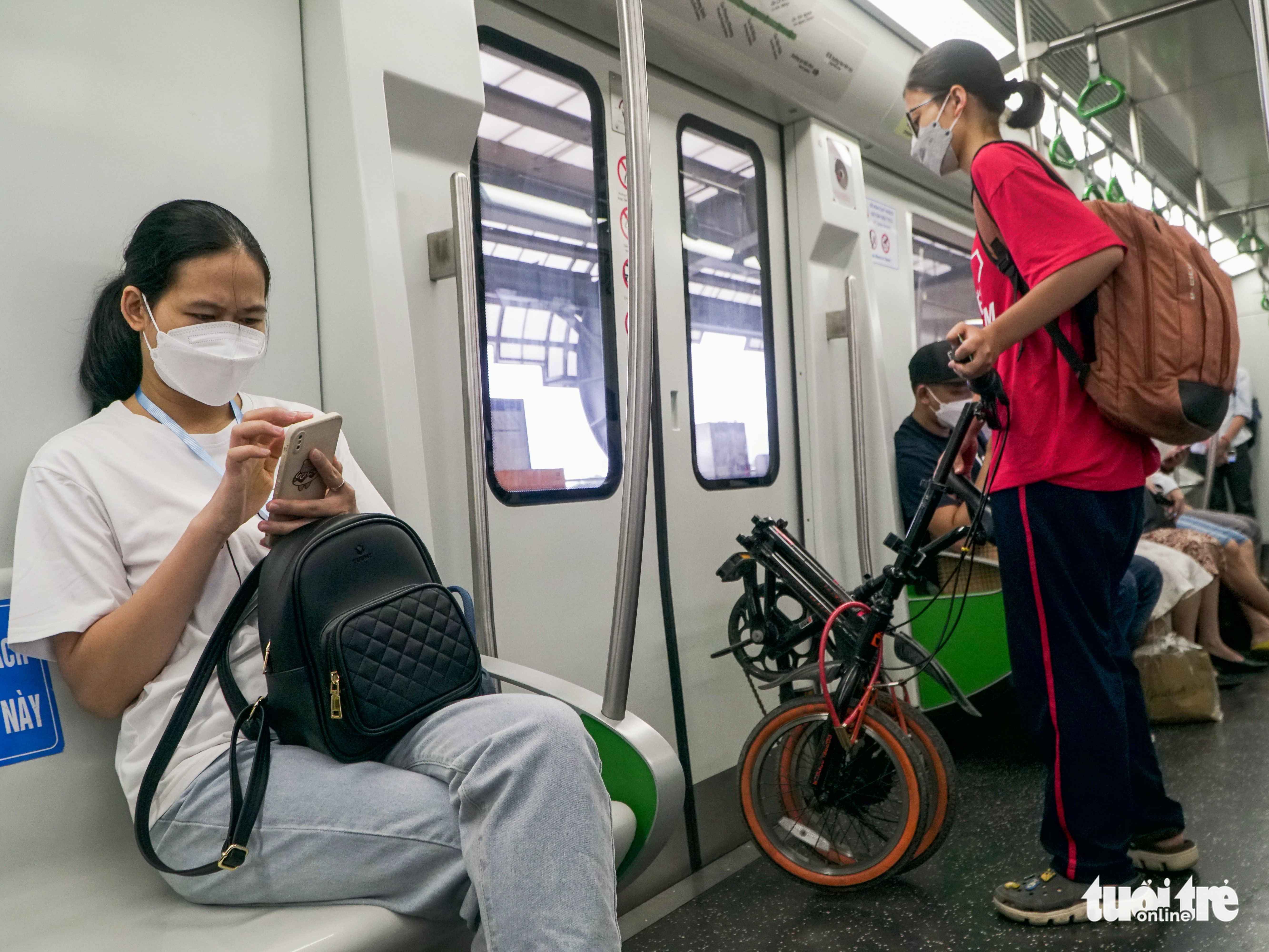 A teenager carries a folding bike on board the Cat Linh-Ha Dong metro line in Hanoi, November 16, 2022. Photo: Pham Tuan / Tuoi Tre