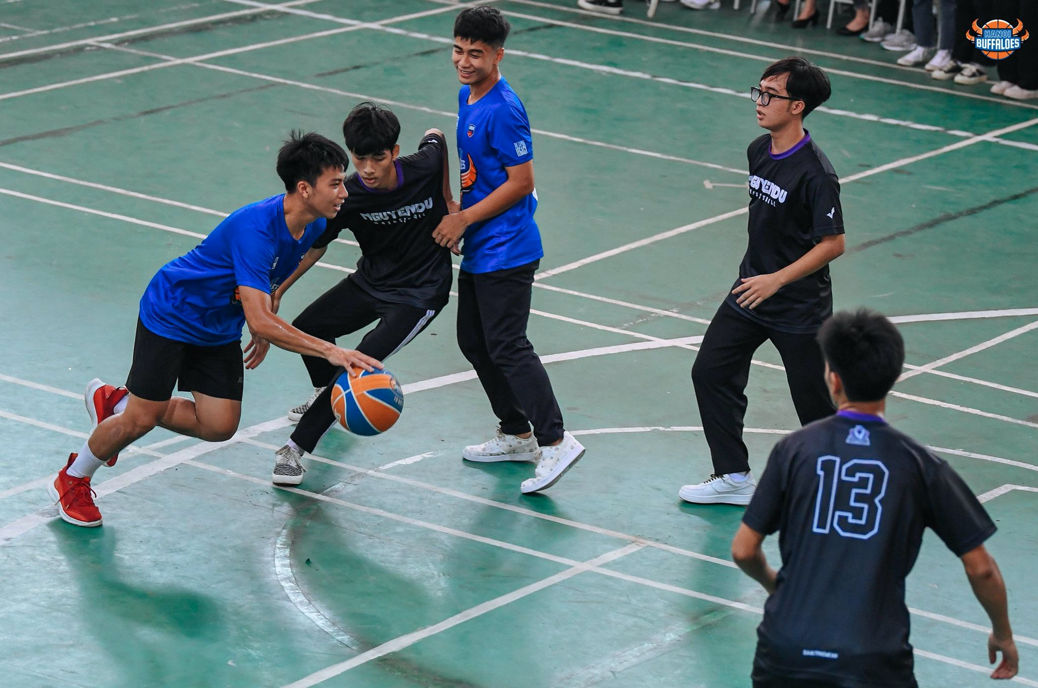 Defender Nguyen Viet Hoang (L), who recently won the VBA 2022 runner-up title with the Hanoi Buffaloes, plays a friendly game with students of Nguyen Du High School in Thanh Oai District, Hanoi. Photo: VBA